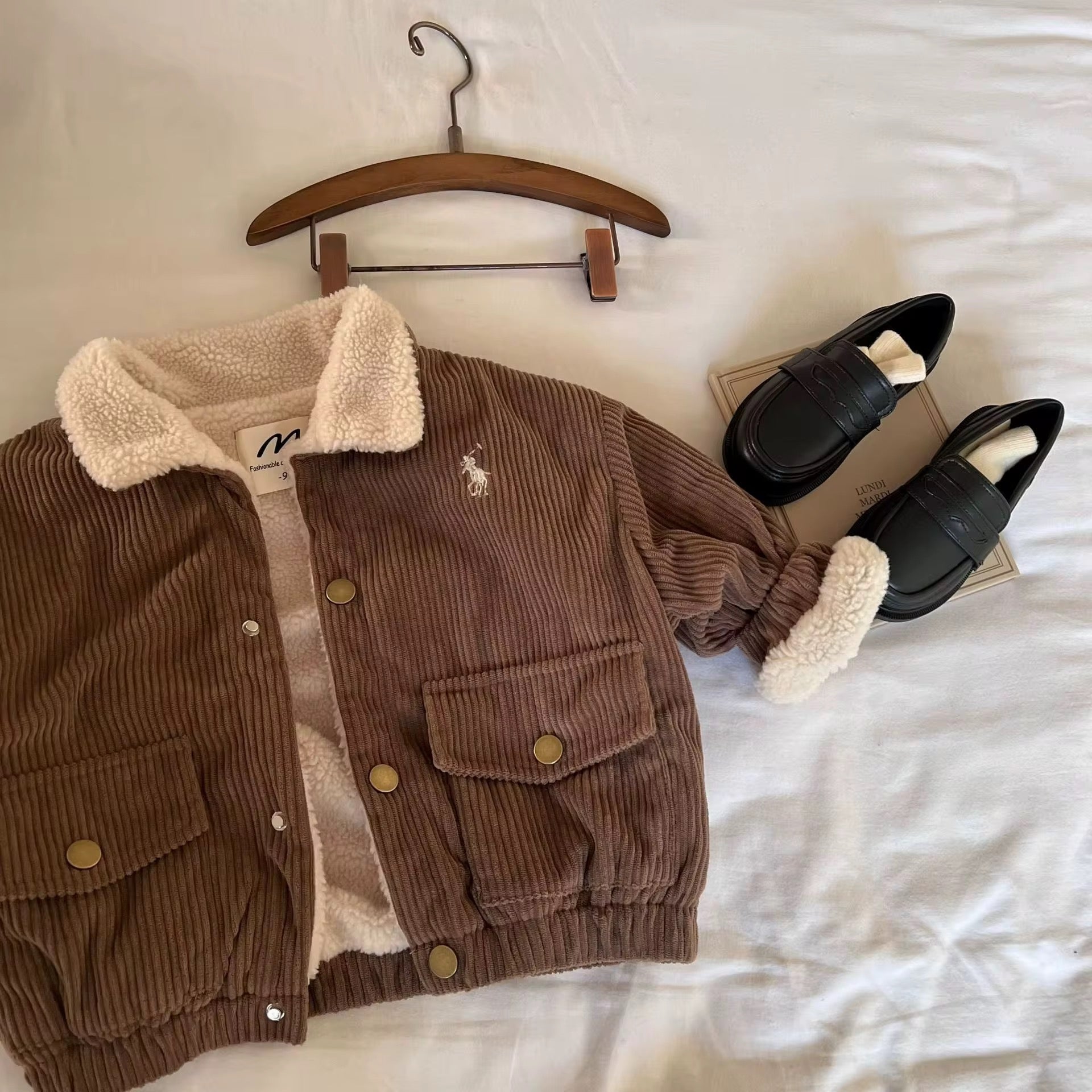 Détails d'une veste en corduroy pour bébé garçon, AURORE LUXURE, avec une élégante doublure en sherpa, idéale pour l'hiver.