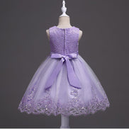 DreamHigh Flower Girl Dress for 3-10 Years Old Girls by AURORE LUXURE, worn by a girl smiling in a lovely purple embroidered dress showcasing pearl embellishments.