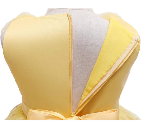 Girl smiling in a yellow dress with flowers, included in the Baby Girls Dresses Summer collection.